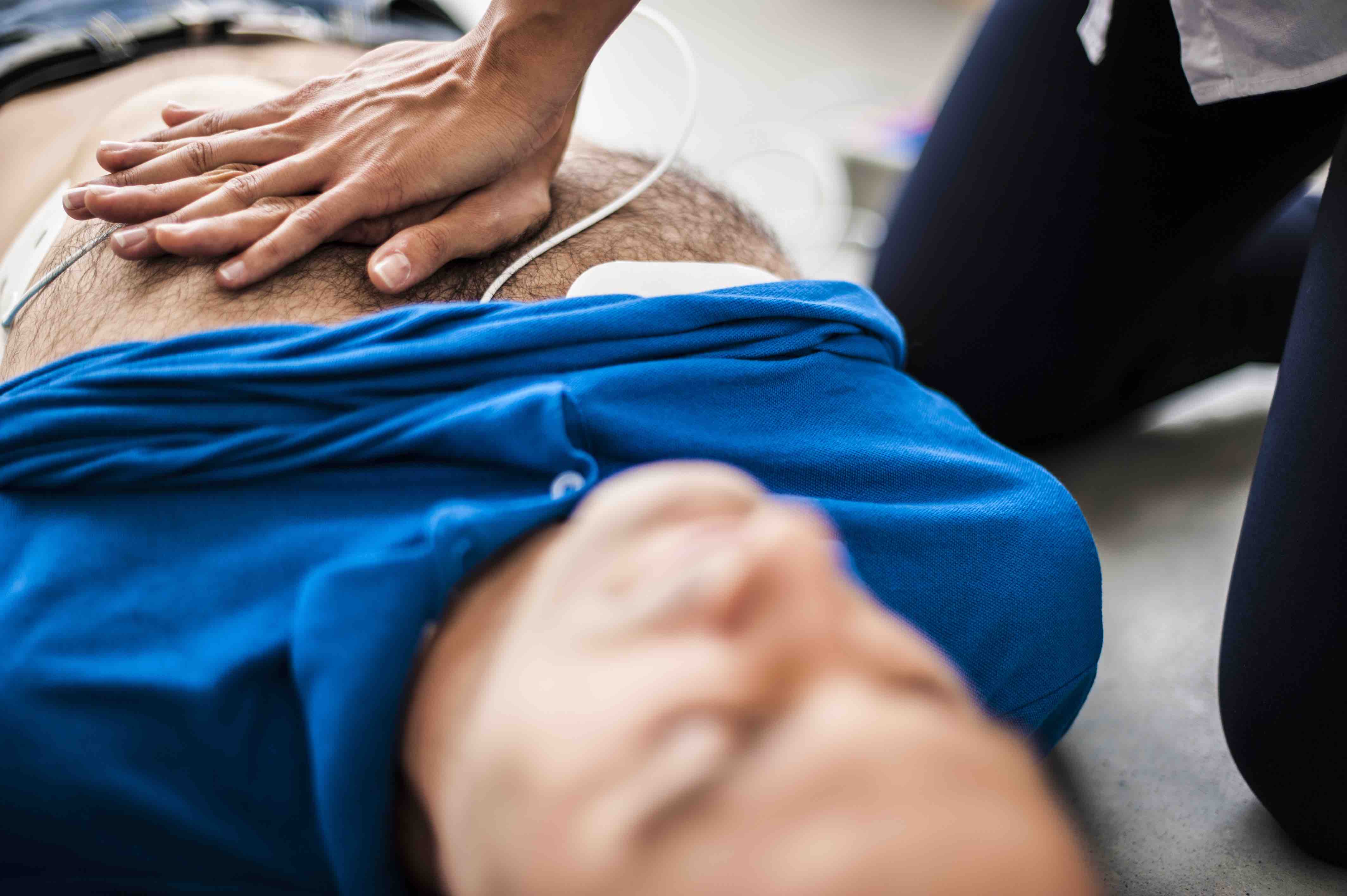 cpr chest thrust man with blue shirt